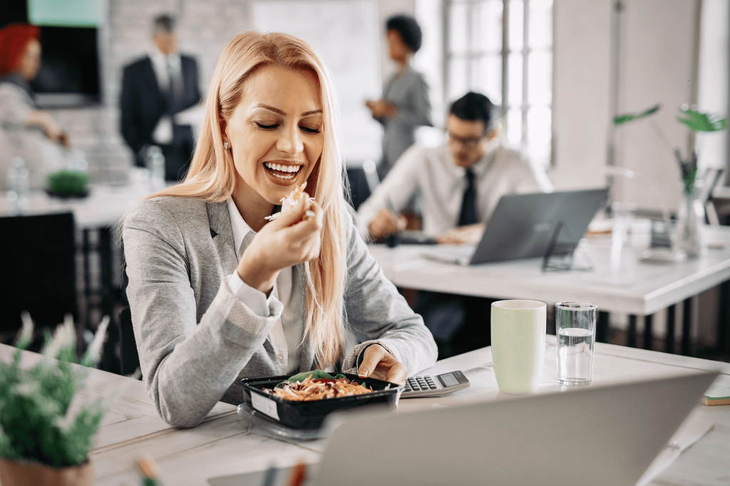 mujer-de-negocios-sonriente-comiendo-alimentos-saludables-en-el-trabajo-y-comiendo-ensalada-de-verduras-para-el-almuerzo (3)